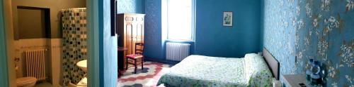 a blue room with a bed and a bathroom at La Fornace in Garessio