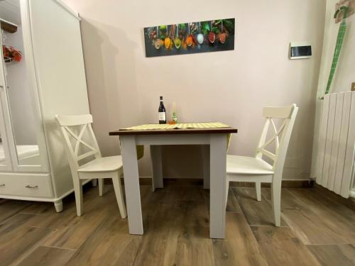a table with two chairs and a bottle of wine at Nicolaus in Sesto Calende