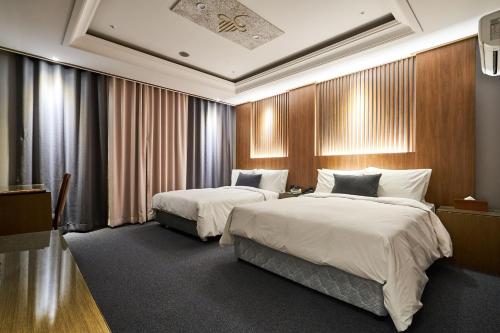 a hotel room with two beds and a television at The Koryo Hotel in Bucheon