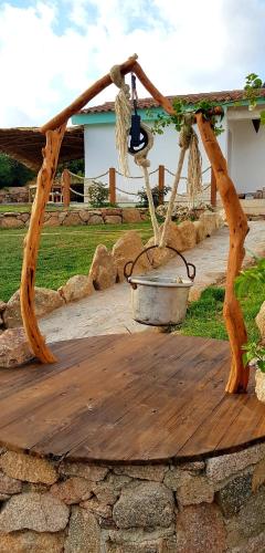 a wooden table with a bucket on top of a stone wall at Tenuta Petra Manna in Palau