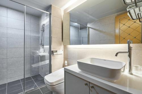 a bathroom with a white toilet and a sink at The Koryo Hotel in Bucheon