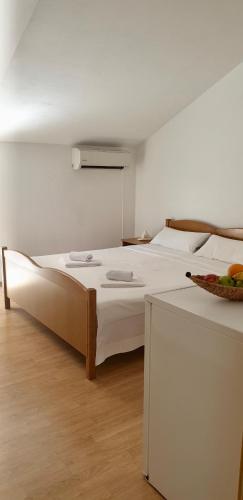 a bedroom with a large white bed and a table at Vila Jela in Baška Voda