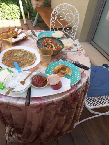 a table with plates of food on top of it at Galit's Zimmer in Sha‘alvim