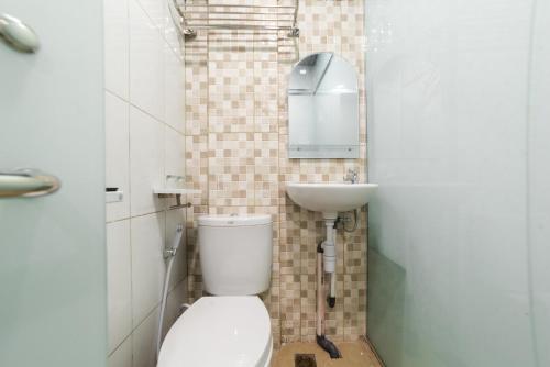 a bathroom with a toilet and a sink at Glamour Hotel and Spa in Medan