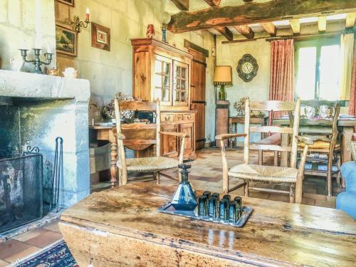 La Grange aux Moines في Berthenay: غرفة معيشة مع طاولة ومدفأة