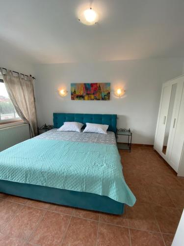 a bedroom with a blue bed in a room at Vila Ammos Mamaia 120 Metri De Plaja in Mamaia Sat/Năvodari