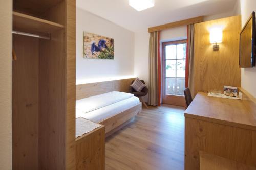 a hotel room with a bed and a window at Gästehaus Brantlhof Zimmer und Ferienwohnungen in Going am Wilden Kaiser in Going
