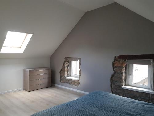 a bedroom with a bed and two windows and a dresser at Dolce Vita Gerolstein -Dani in Gerolstein