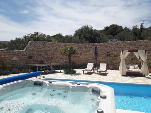 a swimming pool with a hot tub in a yard at Villa Roza Murter in Murter