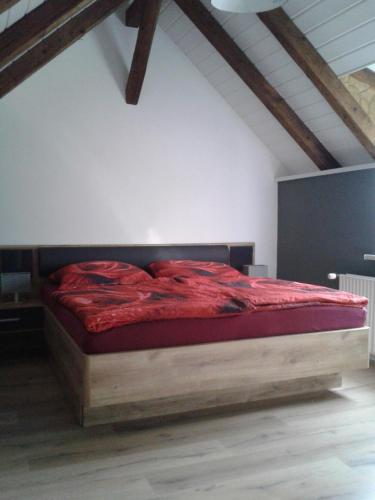 a bedroom with a large red bed in a attic at Bubi Niedlich in Thale
