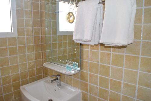 y baño con lavabo, espejo y toallas. en Al-Ashkhara Beach Resort منتجع شاطئ الأشخرة, en Al Sharqiyah