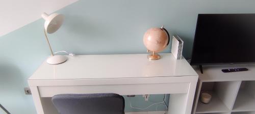 un bureau blanc avec une lampe et un moniteur d'ordinateur dans l'établissement Studio 26m2 centre ville rénové avec parking privé, à La Grande Motte