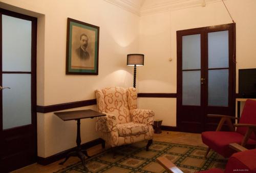 a living room with a chair and a lamp at Casa do Sertório - Casa inteira in Évora