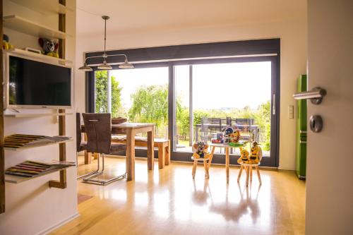 a dining room with a dining table and a large window at Anja's Ferienwohnung Europa Park in Ettenheim