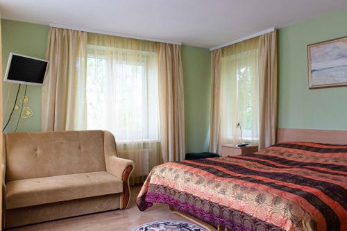 a bedroom with a bed and a chair and a window at Guest house Rasa in Palanga