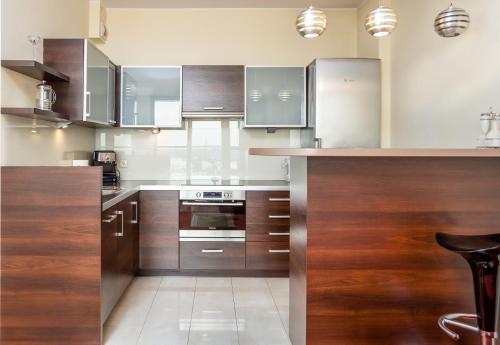 a kitchen with wooden cabinets and stainless steel appliances at Sea Towers "Sweet Dream" in Gdynia