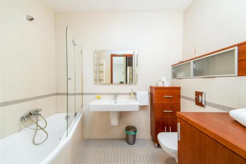 La salle de bains est pourvue d'un lavabo, d'une baignoire et de toilettes. dans l'établissement Sea Towers "Sweet Dream", à Gdynia