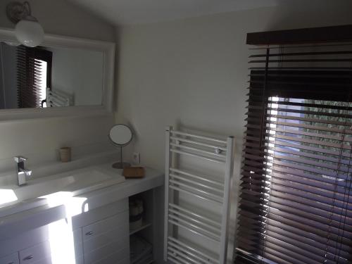 une salle de bain avec un lavabo, un miroir et une fenêtre dans l'établissement TERRASSE DES OCRES, à Roussillon