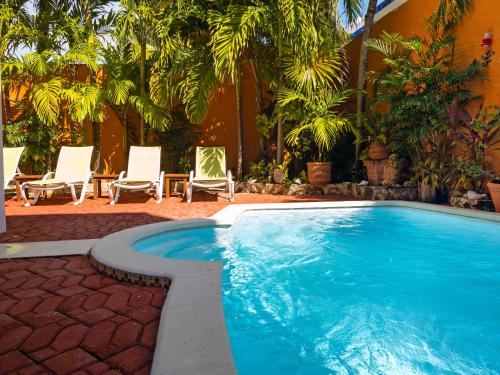 a swimming pool with two chairs and a table at Casa Mulder - Steps to Beach Private Pool Ocean-View Roof in Puerto Morelos