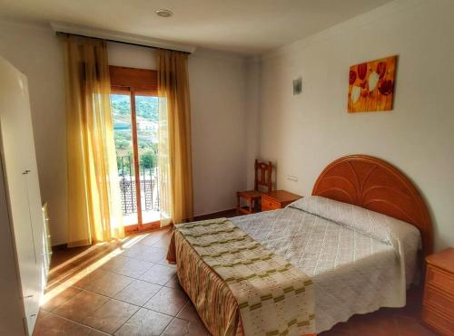 Un pat sau paturi într-o cameră la Casa amplia con terraza en La Viñuela