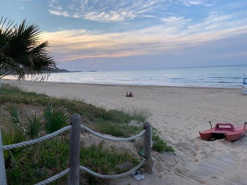 une plage de sable avec une clôture et des personnes sur la plage dans l'établissement Villaggio Camping Oasi, à Vieste