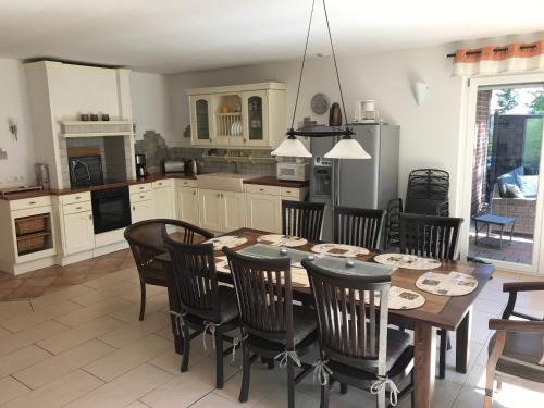 a kitchen and dining room with a wooden table and chairs at Feriendomizil-Stegemann in Trassenheide