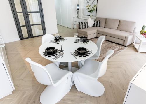 biały stół jadalny i krzesła w salonie w obiekcie BIANCO APARTMENTS w Świnoujściu
