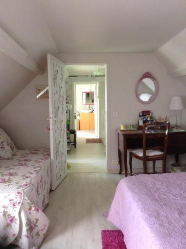 - une chambre avec 2 lits, un bureau et une table dans l'établissement Le Jardin des Poules, à Thiétreville