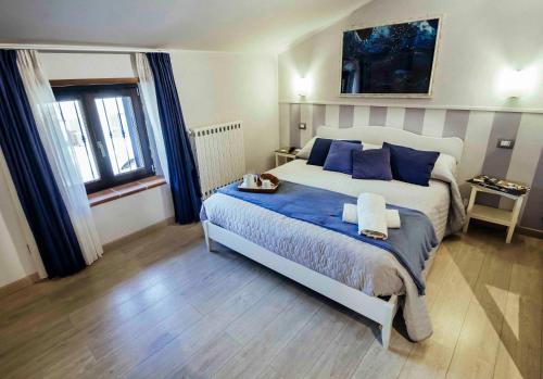 een slaapkamer met een groot bed met blauwe kussens bij B&B Antiche Mura in Tarquinia