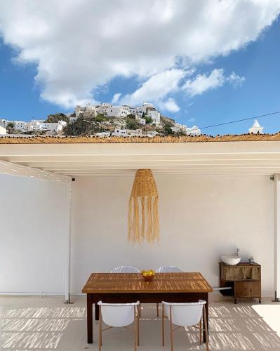 a dining room with a table and white walls at Serifos Olive in Serifos Chora