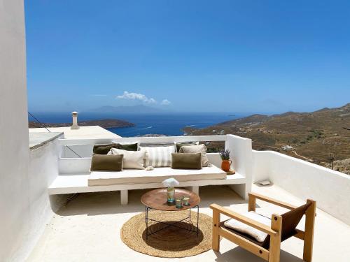 a white couch sitting on a balcony with a table at Serifos Olive in Serifos Chora