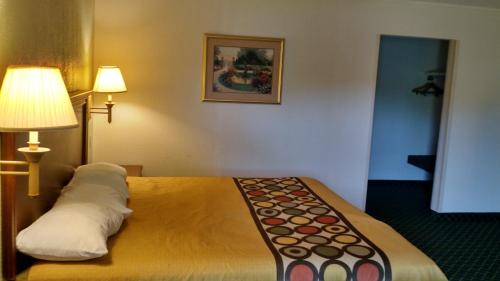 a room with a bed with two lamps on it at Sprucewood Inn in Elyria