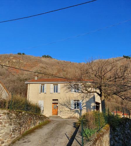 a house on a dirt road in front of a hill at En pleine montagne in Mercus-Garrabet