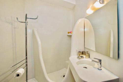 y baño blanco con lavabo y ducha. en Cozy flat in Tinos, en Tinos
