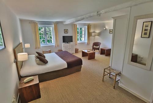 a bedroom with a bed and a living room at Hotel La Maison des Peyrat in Sarlat-la-Canéda