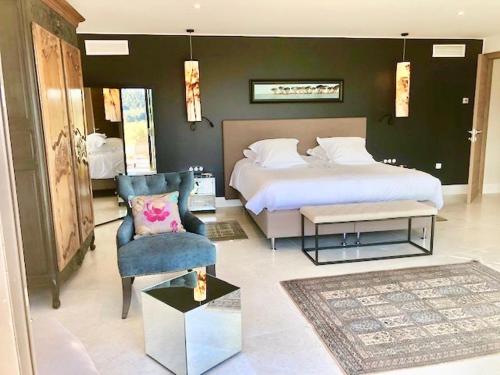 - une chambre avec un grand lit et une chaise dans l'établissement VILLA PADI La Cadière d'Azur, à Laouque