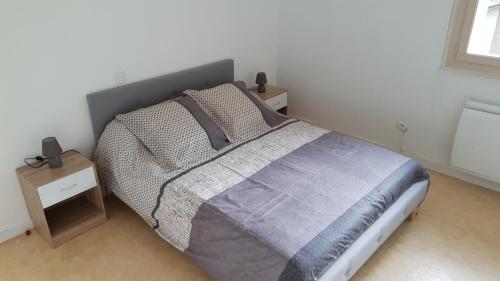 une chambre avec un grand lit et une table de chevet dans l'établissement En pleine montagne, à Mercus-Garrabet