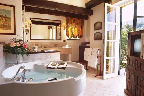 a large bathroom with a tub and a sink at La Meridiana Hotel & Golf Resort in Garlenda