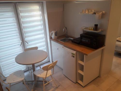 a small kitchen with a small table and a microwave at Sol De Sopot in Sopot