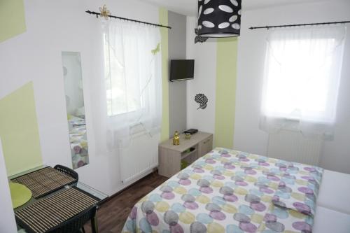 Schlafzimmer mit einem Bett, einem Tisch und einem Fenster in der Unterkunft Apartmány Freesia in Jablonec nad Nisou
