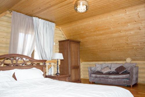 a bedroom with a bed and a couch in a room at Villa Camilla, Затока in Zatoka