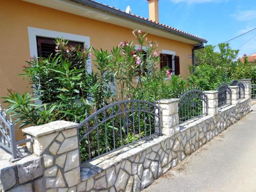 a stone fence with plants in front of a house at Villa AnaAngela in Malinska