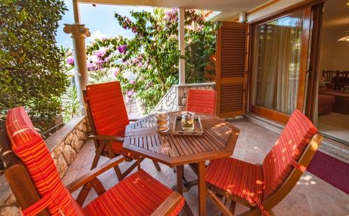 una mesa de madera y sillas en un porche en Villa Magnolija, en Cres