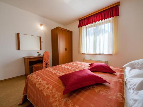 a bedroom with a bed with red pillows on it at Villa Magnolija in Cres