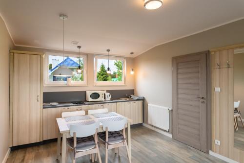 a kitchen and dining room with a table and chairs at Farys in Jastrzębia Góra