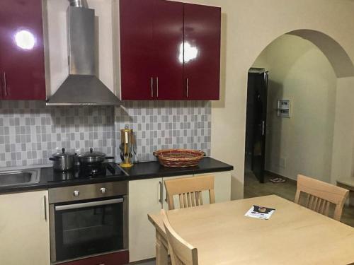 a kitchen with a table and a kitchen with purple cabinets at Agaraj apartament in Orikum