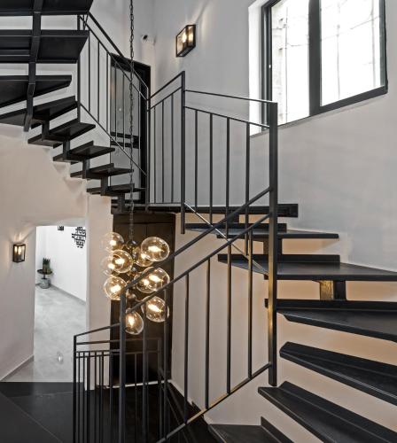 a black spiral staircase with a chandelier at Old City Boutique Hotel in Jerusalem