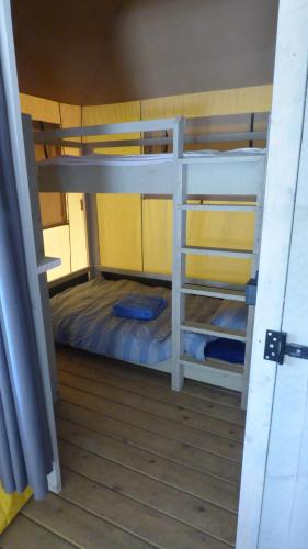 a room with two bunk beds in a boat at La tente de la plage in Plouha