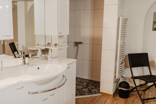 y baño blanco con lavabo y ducha. en FeWo B50, en Beckingen