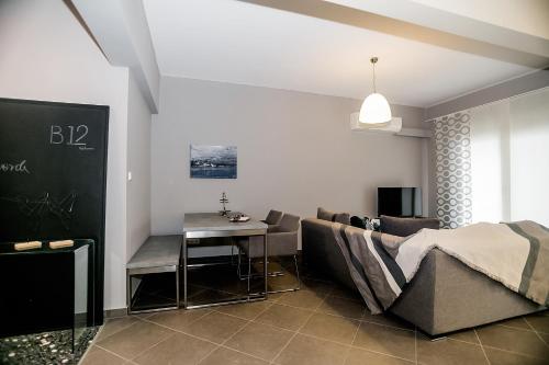 ein Wohnzimmer mit einem Sofa und einem Tisch in der Unterkunft B12 new & modern seafront apartment in Alexandroupoli